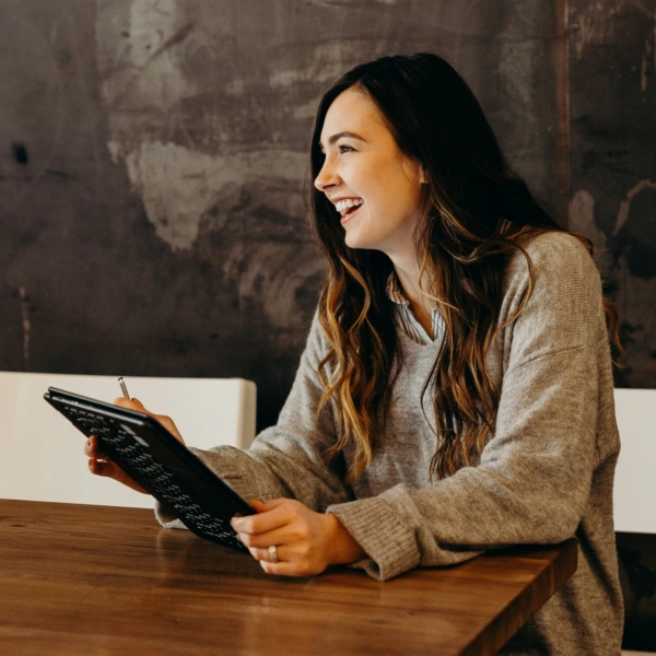 smiling woman holding an electronic tablet
