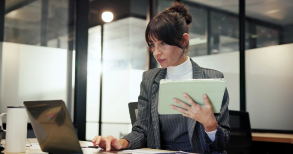 Business woman in office with a laptop and tablet